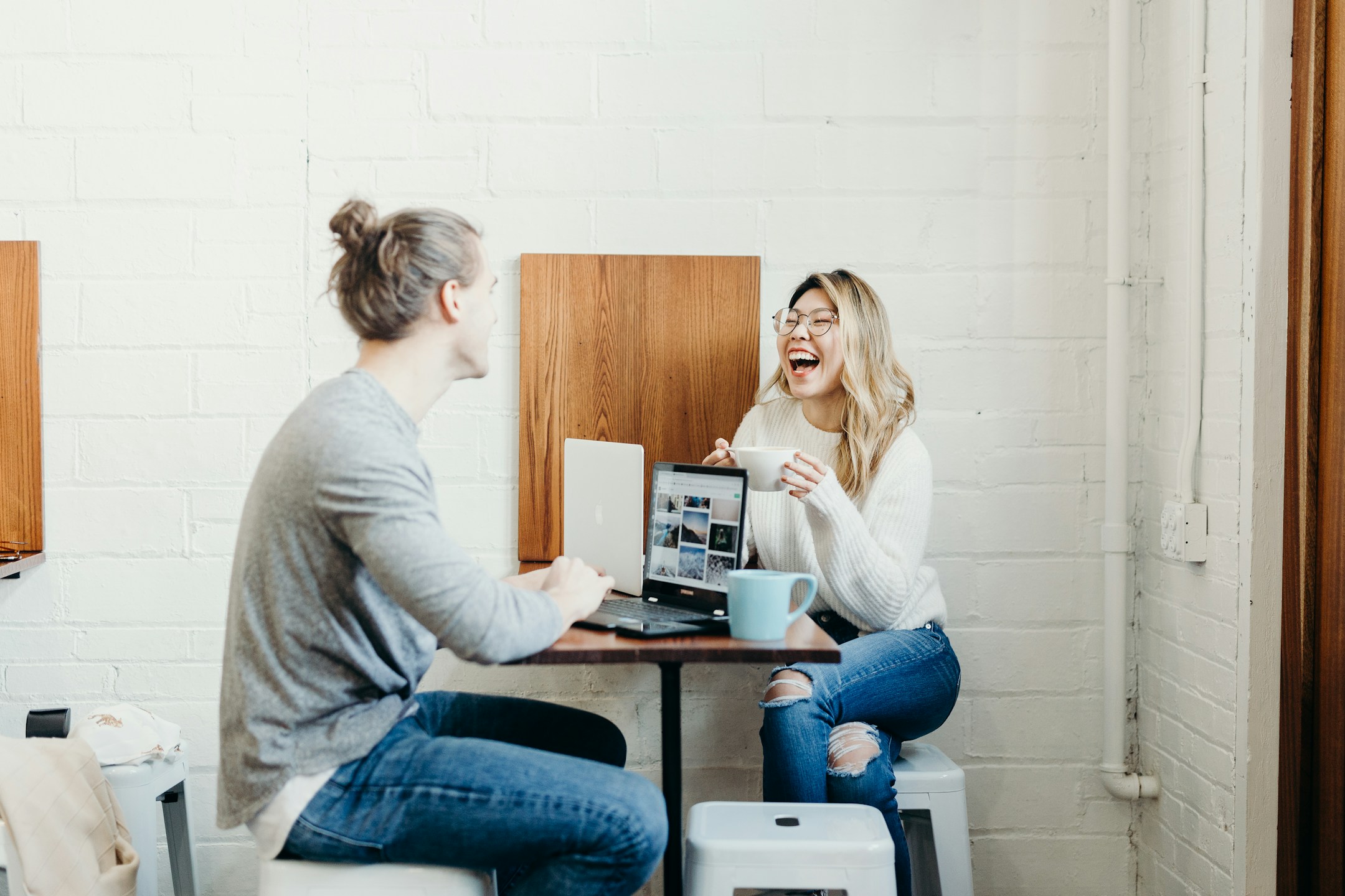 Two people having a relaxed business meeting at a dining table, the kind of post-qualification conversation an AE actually wants to have.
