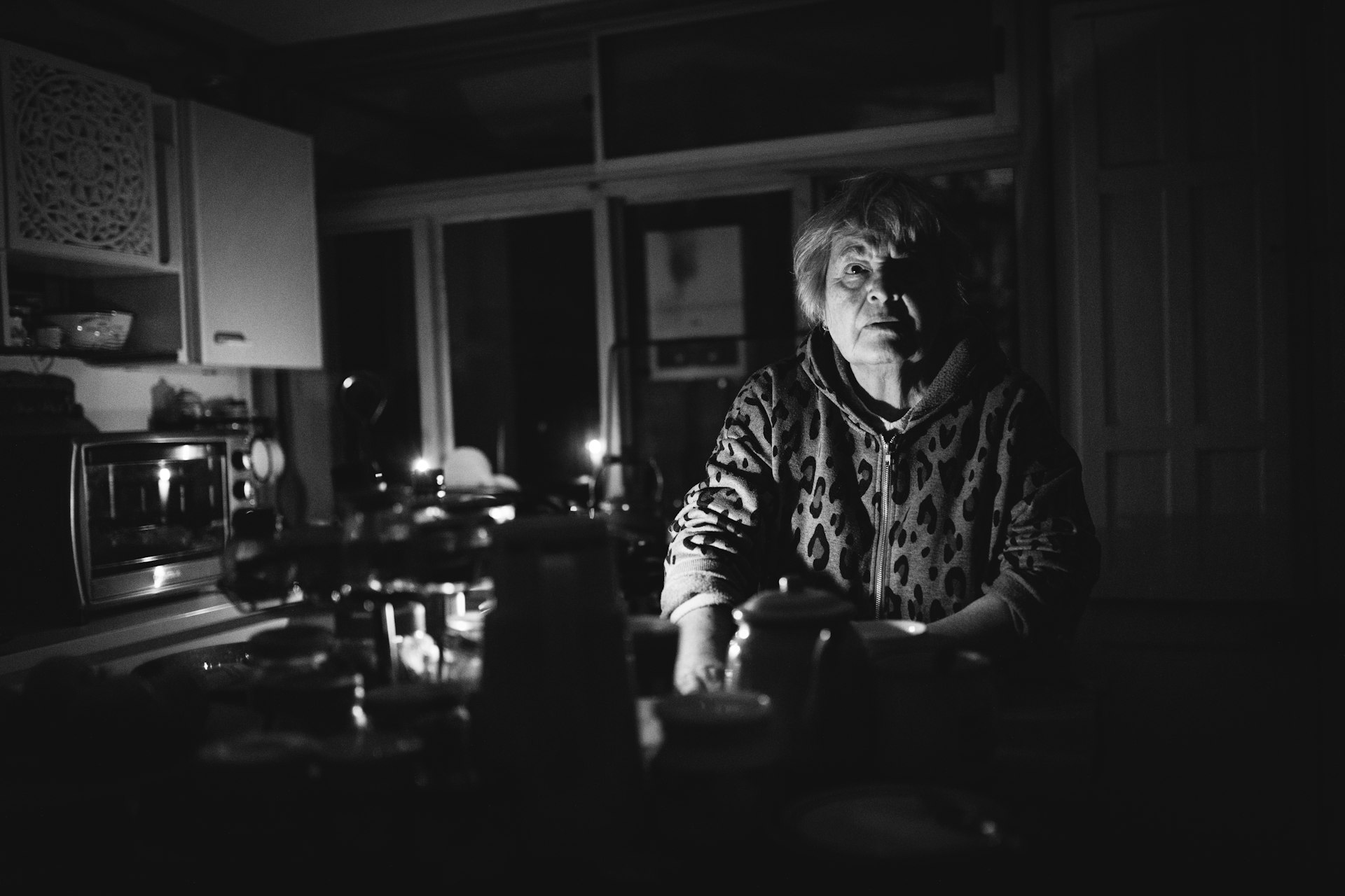 A woman in her 70s holding a phone in a sunlit kitchen, the visual of the user the AI agent industry has historically underserved.