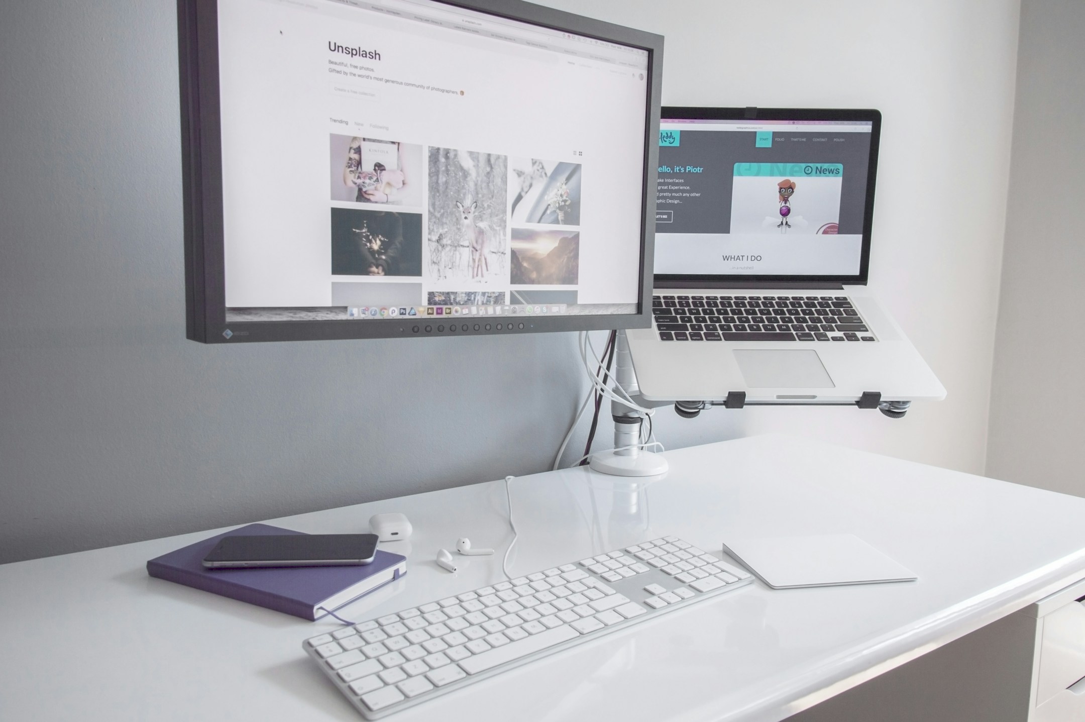 A monitor and MacBook Air on a clean desk, the workspace of someone running their business solo.
