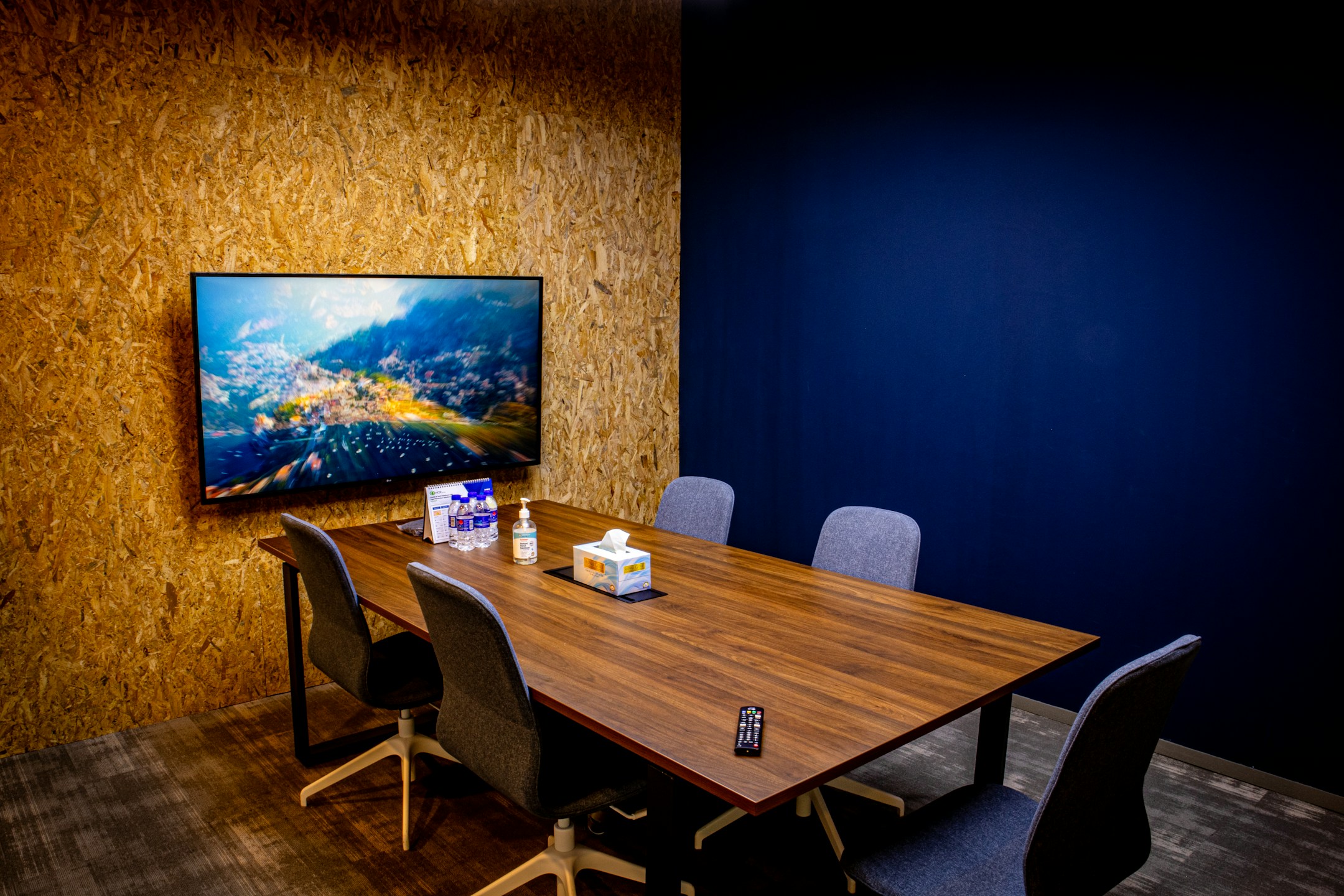 A modern conference room with a TV at the end of the table, the kind of meeting where a recap matters.