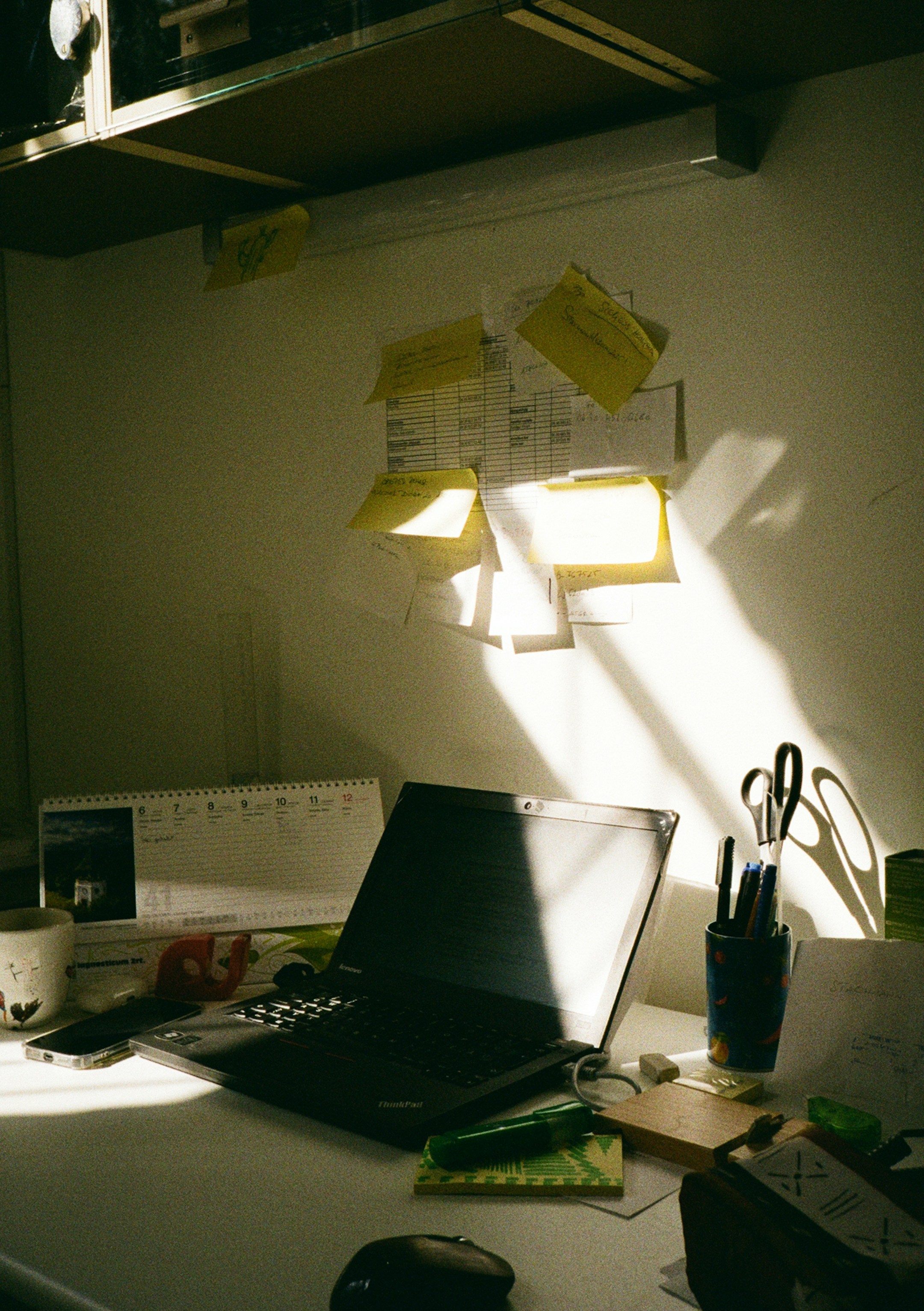 A laptop with sticky notes around it, the disorganized state most owners feel at year-end before invoicing got automated.