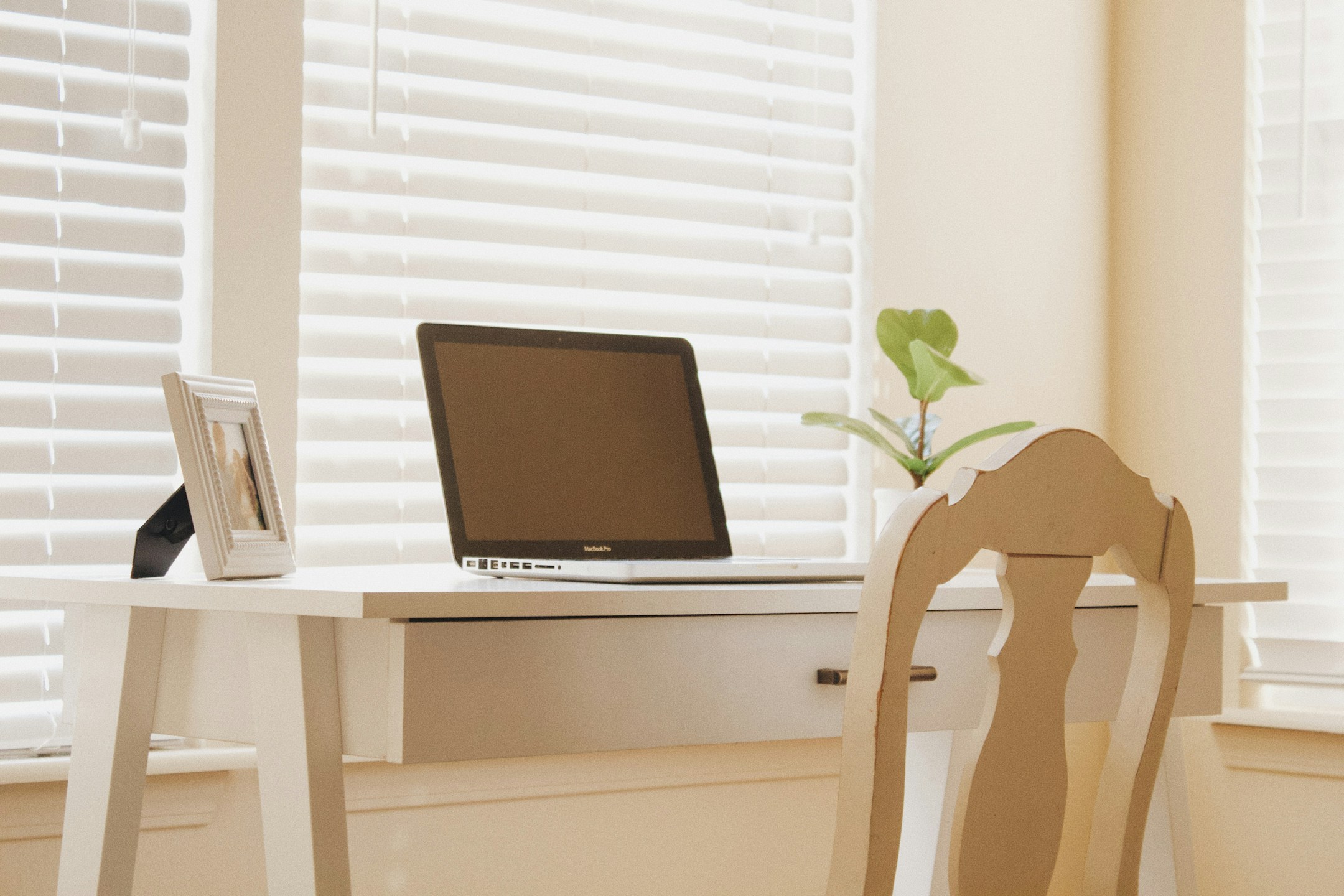 A laptop on a wooden desk, calm afternoon light. The visual of work that schedules itself.