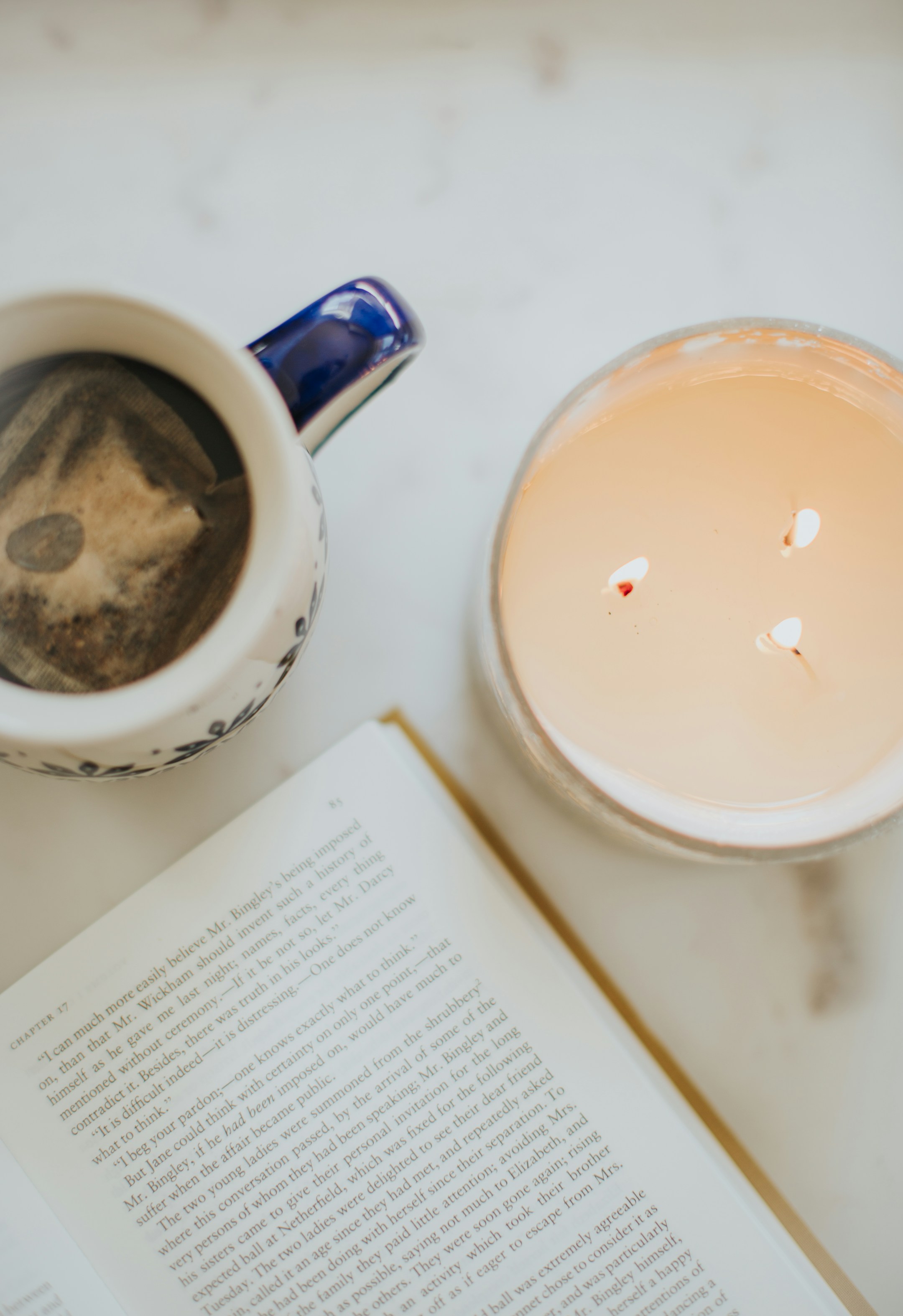 A clean white ceramic mug on a plate, soft white fabric, the visual of a habit being formed.