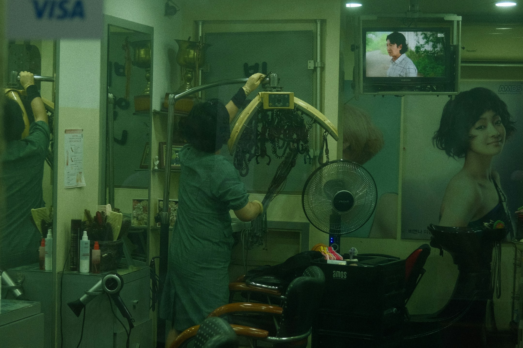 A woman at a salon getting her hair styled. The salon's phone rings during every appointment, and an AI receptionist handles those calls so the stylist does not have to break flow.