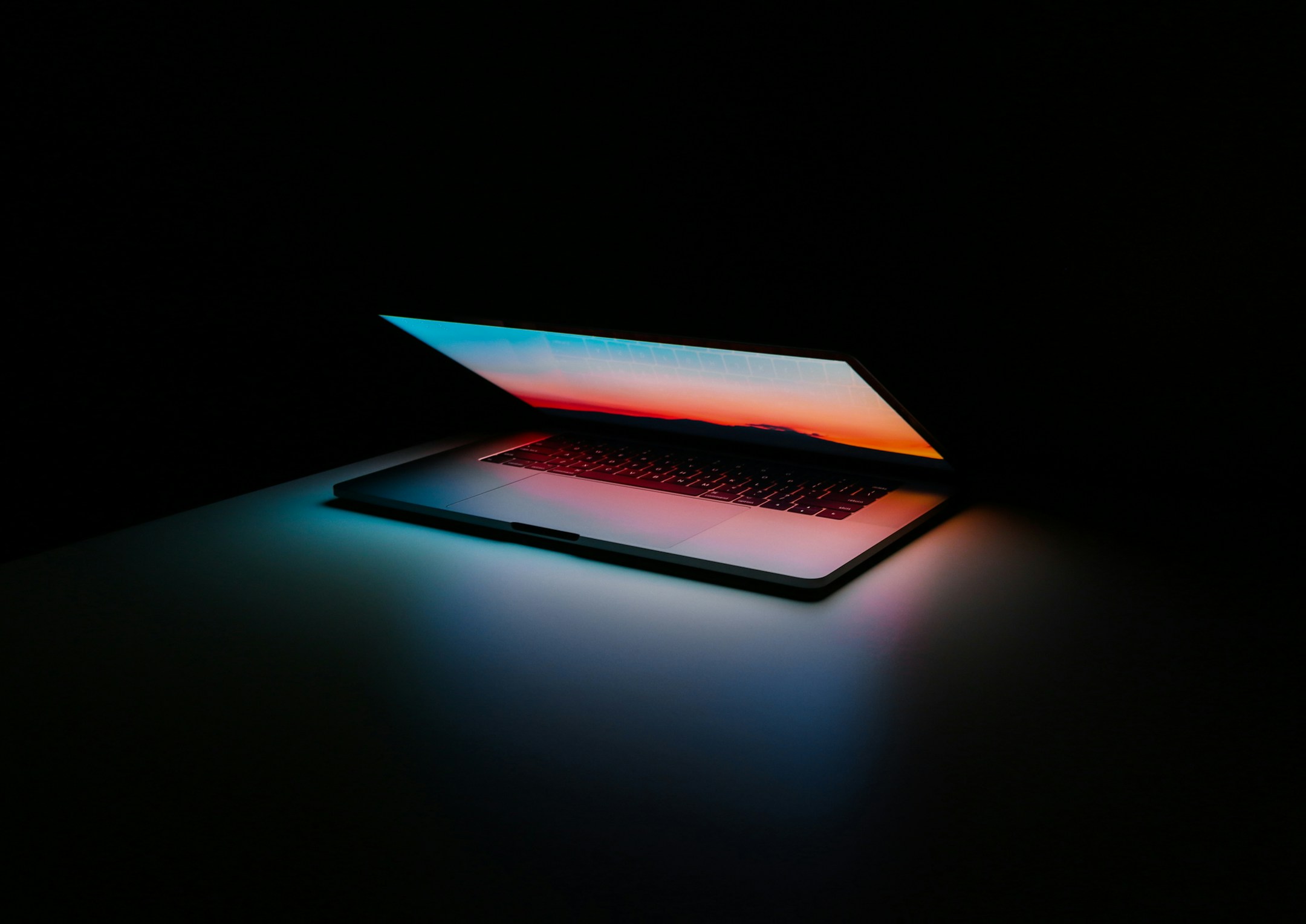 An overhead view of a laptop on a clean wooden desk, the kind of workspace where Claude Code is the daily driver.