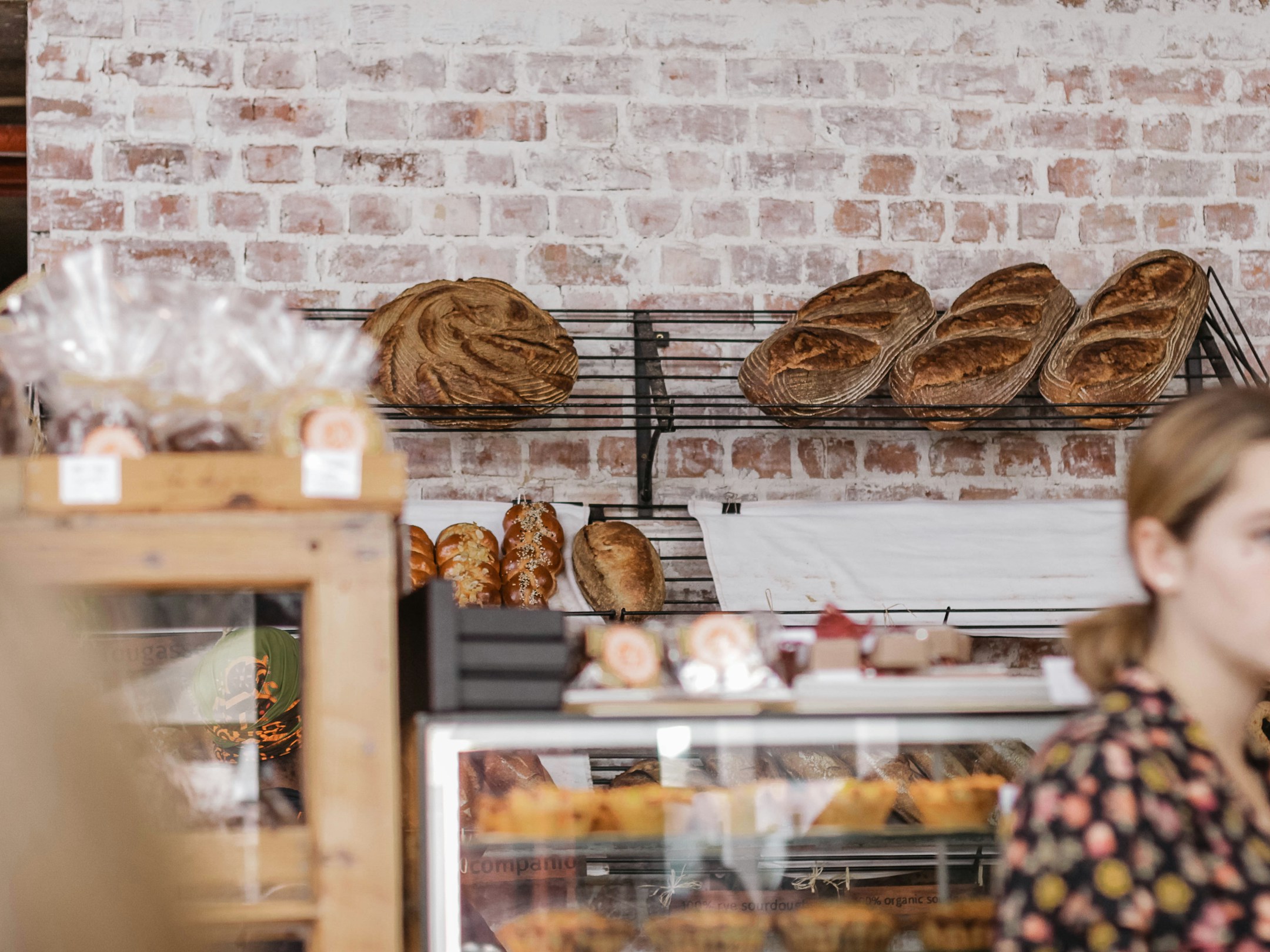 A bread display rack in a bakery, plain and warm, the kind of inventory the agent is asked about a hundred times a week.