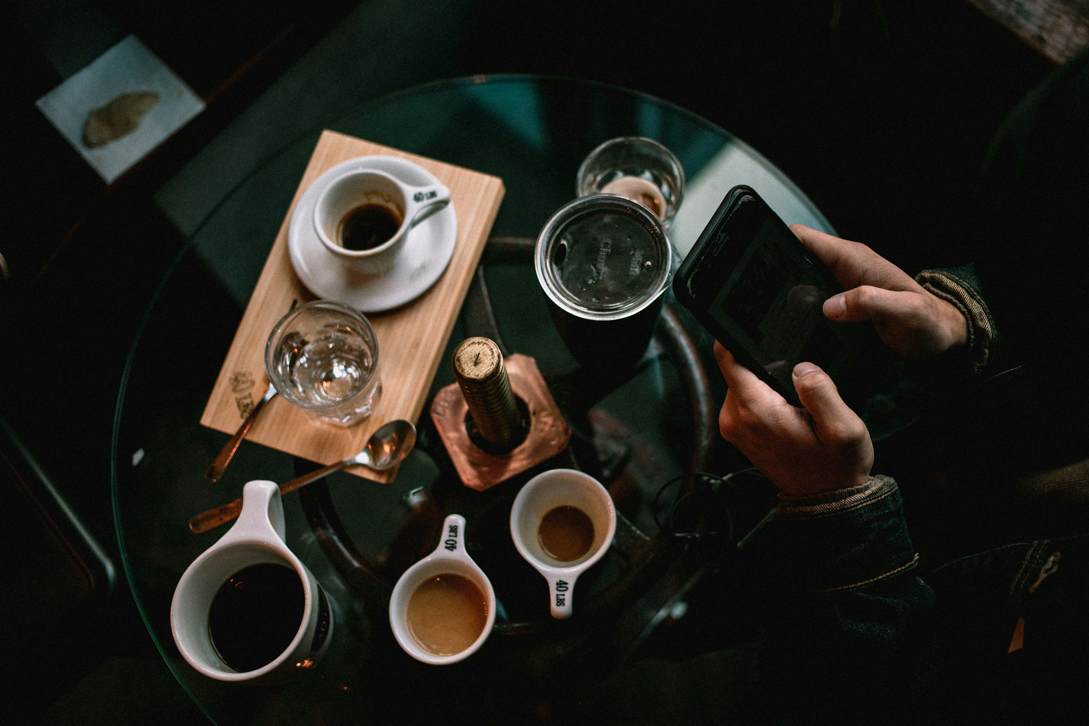 A phone on a cafe table, top-down. The case for the agent that lives where the conversation already is.