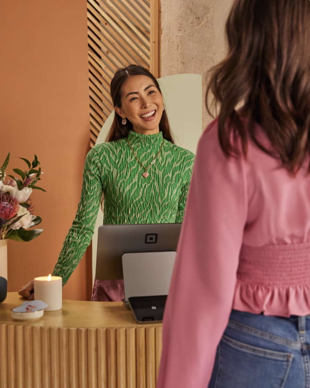 A salon receptionist using a Square terminal -- the kind of business Ajeris helps run.